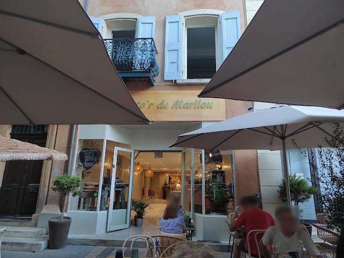 La façade du Comptoir de Marilou, volets bleus et terrasse sous les parasols