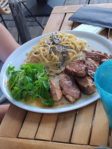 Magret de canard aux morilles et spaghetti, servi sur une table en bois