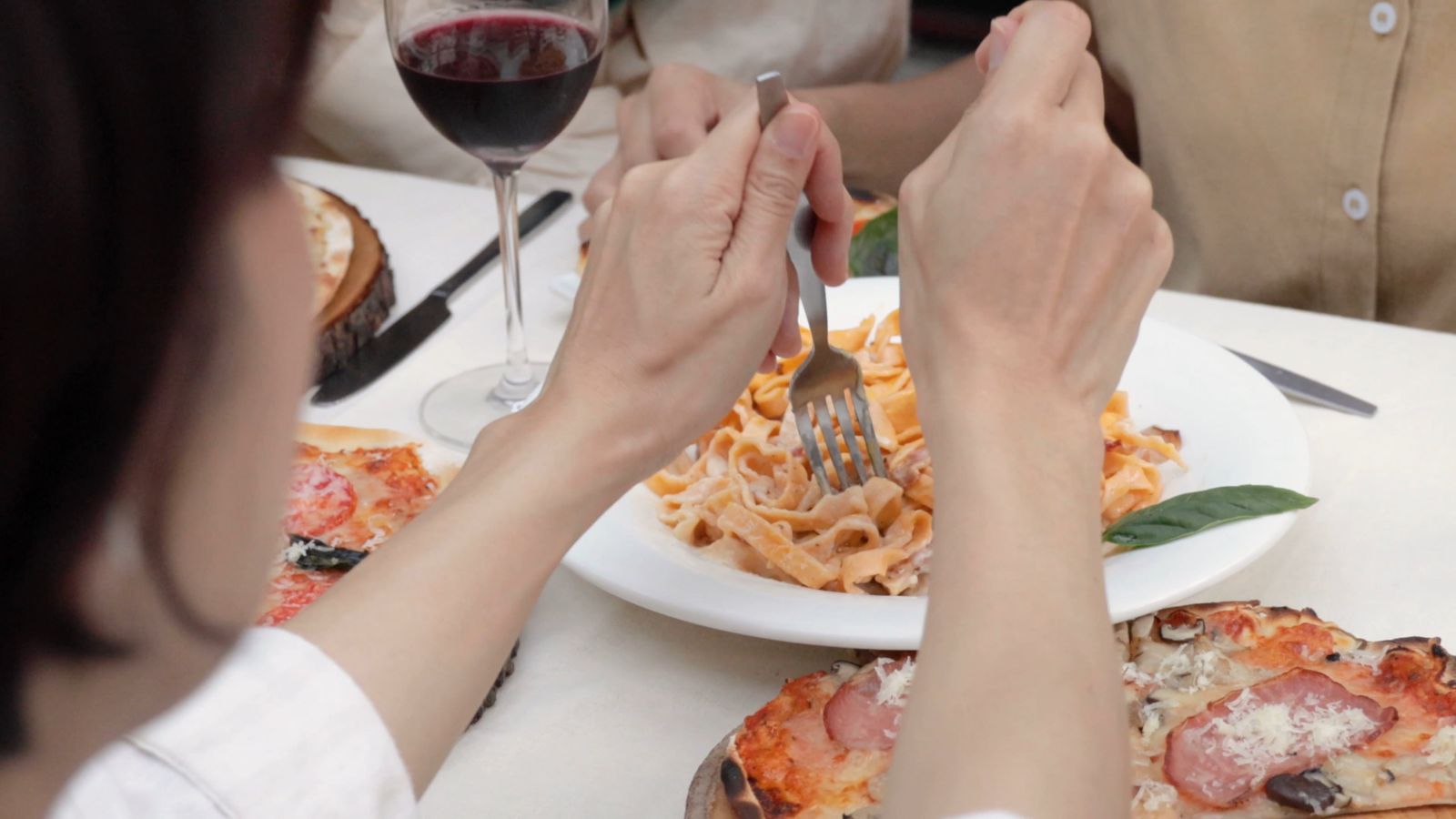 Tagliatelles enroulées à la fourchette, verre de vin rouge